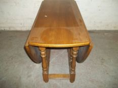 A SOLID OAK DROP LEAF DINING TABLE