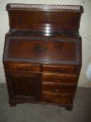 A CARVED LEATHER INLAID MAHOGANY WRITING BUREAU