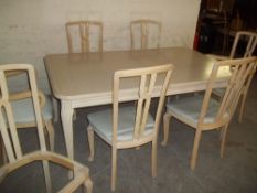 A FRENCH STYLE MODERN EXTENDING TABLE AND 6 CHAIRS S/D AND A SPARE CHAIR WITH A LOOSE LEG