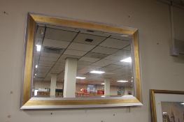 A LARGE FRAMED BEVEL EDGED MIRROR 106 CM X 76 CM