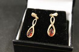 A PAIR OF UNMARKED YELLOW METAL DROPPER EARRINGS SET WITH GARNET TYPE TEARDROP STONES