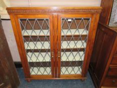 A VINTAGE OAK GLAZED TWO DOOR BOOKCASE W-106 CM