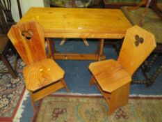 A PINE TRESTLE STYLE TABLE AND TWO CHAIRS