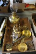 A TRAY OF ASSORTED BRASSWARE TO INCLUDE TWO OIL LAMPS, SAUCEPAN, TRIVETS ETC