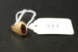 A MARQUISE SHAPED CONTINENTAL RING STAMPED 750 SET WITH A RUBY STYLE STONE - APPROX WEIGHT 4 G