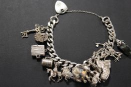 A CHARM BRACELET AND CHARMS WITH HALLMARKED SILVER HEART SHAPED CLASP