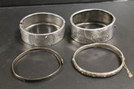 A FINE HALLMARKED SILVER HINGED BANGLE, TOGETHER WITH TWO LARGER UNMARKED WHITE METAL HINGED BANGLES