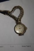 A LADIES 9CT TISSOT BRACELET WATCH ON 9CT GOLD STRAP INSCRIPTION TO THE BACK