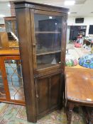 A REPRODUCTION OAK GLAZED CORNER CABINET