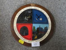 A CIRCULAR WOODEN PLAQUE 'C.O.S.A. NORTH WESTERN AREA NCB EST 1947'