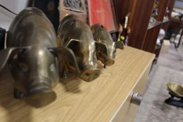 A SET OF THREE GRADUATED BRASS PIGS - ONE BEING CONVERTED TO A MONEY BANK