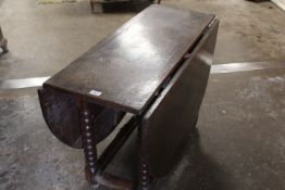 AN ANTIQUE OAK DROPLEAF TABLE WITH GATE-LEG MECHANISM