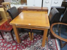 A MODERN OAK EXTENDING DINING TABLE AND FOUR CHAIRS