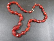 A FACETED AMBER BEAD NECKLACE