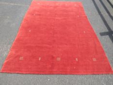A LARGE MAINLY RED GROUND WOOLLEN CARPET APPROX 300 X 200 CM