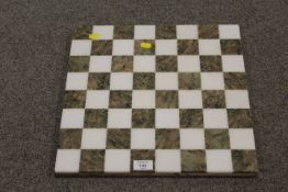 A MARBLE STYLE POLISHED STONE CHESS BOARD
