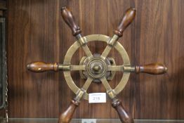 A SMALL BRASS SHIPS WHEEL
