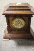 A CARVED WOODEN MANTLE CLOCK