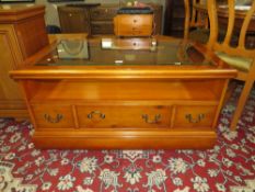 A MODERN GLASS TOPPED COFFEE TABLE WITH DRAWERS