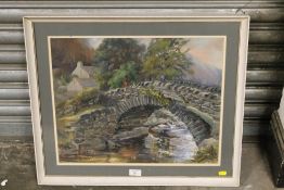 A FRAMED AND GLAZED OIL ON BOARD OF A STONEWALL BRIDGE OVER A STREAM SIGNED IN RED LOWER RIGHT