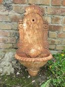 A CAST IRON WALL MOUNTED WATER FEATURE
