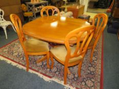 A MODERN EXTENDING DINING TABLE & FOUR CHAIRS