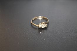 A 9CT GOLD AND THREE STONE ILLUSION SET DIAMOND RING