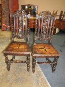 A PAIR OF CAROLEAN STYLE CARVED OAK HALL CHAIRS