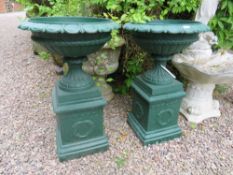 A PAIR OF CAST URNS ON STANDS RAISED ON SQUARED PLINTHS, H 81 cm (2)