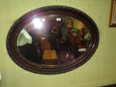 AN EARLY 20TH CENTURY OVAL WALL MIRROR