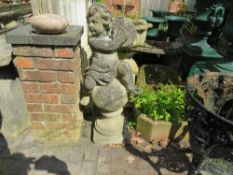 A LARGE GARDEN STONE STATUE DEPICTING A CHERUB PLAYING CYMBALS WHILST RESTING ON A STONE BALL, H