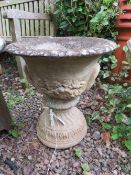 A GARDEN STONE CIRCULAR URN ON PLINTH