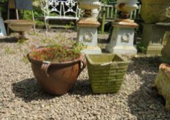 A TERRACOTTA STYLE GARDEN URN AND A SQUARE BRICK EFFECT URN (2)