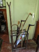 A VINTAGE OAK STICK STAND WITH ASSORTED STICKS