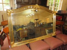A MODERN ARCHED GILT FRAMED OVERMANTLE MIRROR - H 118 cm W 118 cm