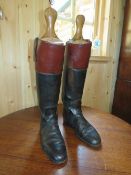 A TRADITIONAL TAN AND BLACK LEATHER PAIR OF HUNTING BOOTS WITH WOODEN TREES