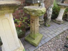 A RUSTIC EFFECT STONE BIRD BATH