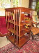AN EDWARDIAN MAHOGANY REVOLVING BOOKCASE WITH SATINWOOD INLAID DETAIL