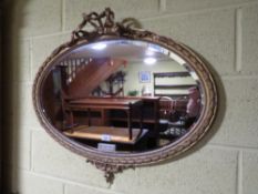 AN EARLY 20TH CENTURY GILT OVAL WALL MIRROR, W 81 cm