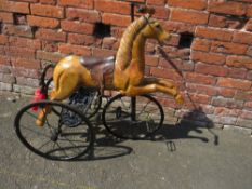 A NOVELTY REARING HORSE ON A CAST TRICYCLE BASE