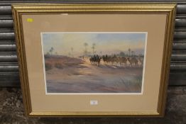 A FRAMED AND GLAZED WATERCOLOUR OF A DESSERT CAMEL TRAIN BY TREVOUR WAUGH ENTITLED CARAVAN'S AT