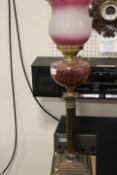 A TWIN DUPLEX BURNER VINTAGE OIL LAMP WITH CRANBERRY STYLE RESERVOIR AND DECORATIVE SHADE