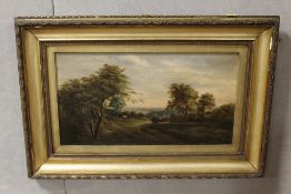 A GILT FRAMED OIL ON CANVAS OF A RURAL SCENE