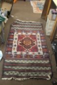 A VINTAGE HAND KNITTED TURKISH RUG WITH A UNUSUAL KLIM END PANELS