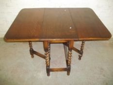 A SOLID OAK DROPLEAF TABLE WITH BARLEY TWIST LEGS