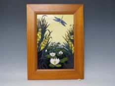 A RECTANGULAR FRAMED MOORCROFT POTTERY PLAQUE DEPICTING WATERLILIES AND DRAGONFLY, impressed and
