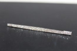 A GRADUATING DIAMOND SET BROOCH, with twenty nine brilliant cut diamonds channel set in unmarked