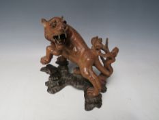 A 20TH CENTURY JAPANESE CARVED HARDWOOD TIGER, on a naturalistic wood base, H 19.5 cm, W 18 cm