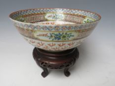 A CHINESE PORCELAIN BOWL DECORATED WITH TWO DRAGONS, raised on a hardwood pierced stand, Bowl H 7.