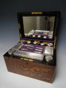 A FINELY FIGURED WALNUT DRESSING BOX WITH A FITTED INTERIOR COMPRISING TEN HALLMARKED SILVER